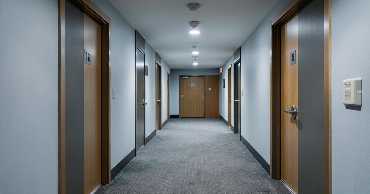 An empty hotel corridor with numbered doors