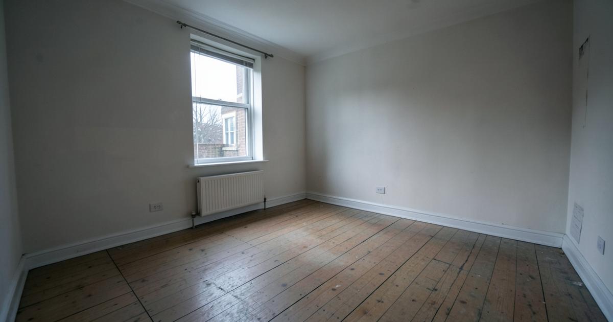 An empty unfurnished room with bare floorboards